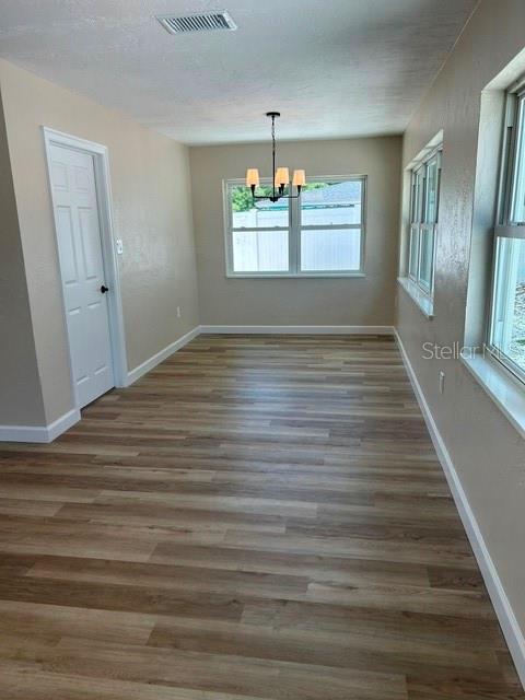 A dining room features light wood-look flooring, a chandelier, and windows overlooking a fenced yard — 3066 66TH WAY N, ST PETERSBURG, FL