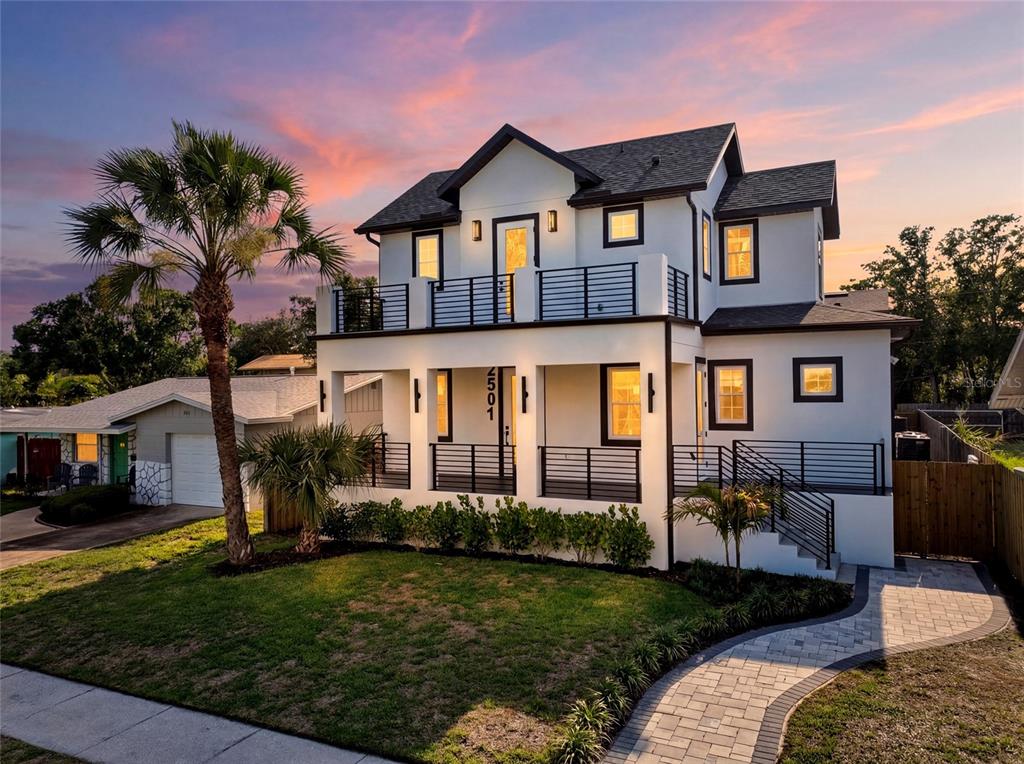 A two-story white house with black trim, a front porch, and an upper balcony at sunset — 2501 QUINCY STREET S, ST PETERSBURG, FL
