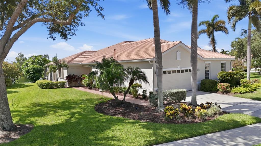 A single-story house with a tiled roof, a two-car garage, and palm trees in front — 8050 VICTORIA FALLS CIRCLE, SARASOTA, FL