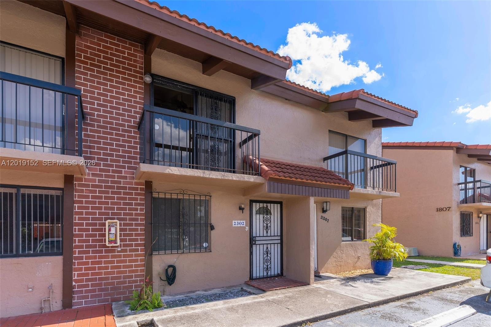 The exterior of a two-story townhouse features a brick facade, stucco walls, and balconies — 1811 SW 107th Ave # 2302, Miami FL 33165, MIAMI, FL