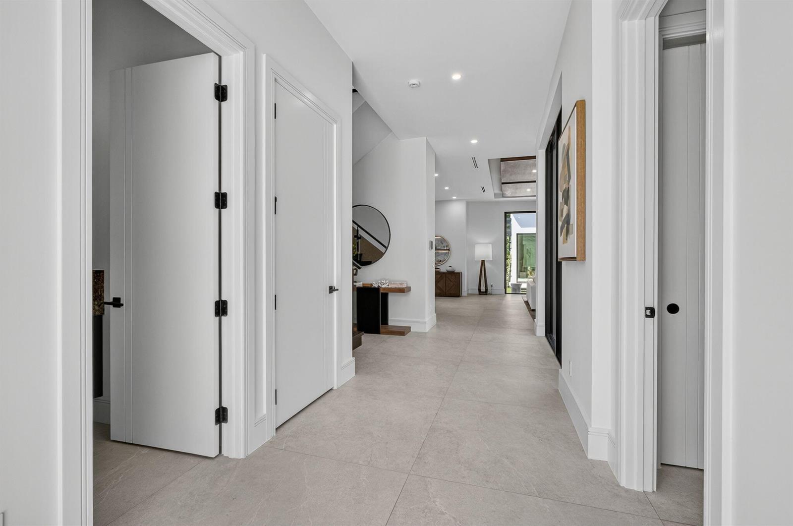 A bright hallway with light tile floors leads toward an open living area and exterior view — 123 Murray Road, West Palm Beach FL 33405, WEST PALM BEACH, FL