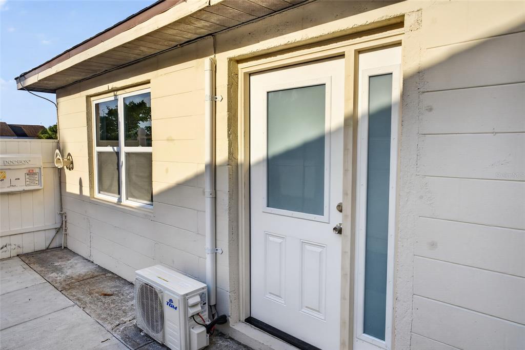 An exterior view of a white building featuring a frosted glass door and window — 536 ROYAL PALM DRIVE, KISSIMMEE, FL