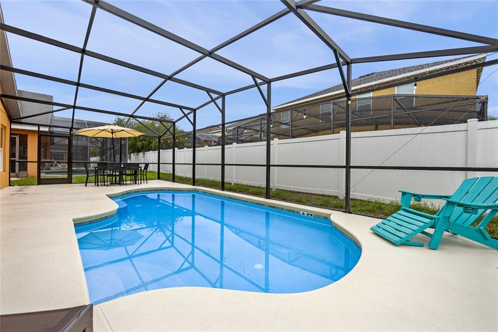 A swimming pool with a screen enclosure and a patio area in a backyard — 2509 DHARMA CIRCLE, KISSIMMEE, FL