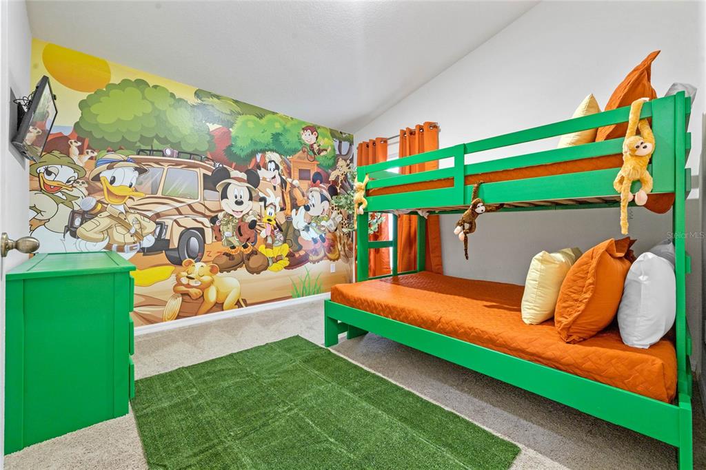A children's bedroom features a green bunk bed, a jungle-themed mural, and a green rug — 2509 DHARMA CIRCLE, KISSIMMEE, FL