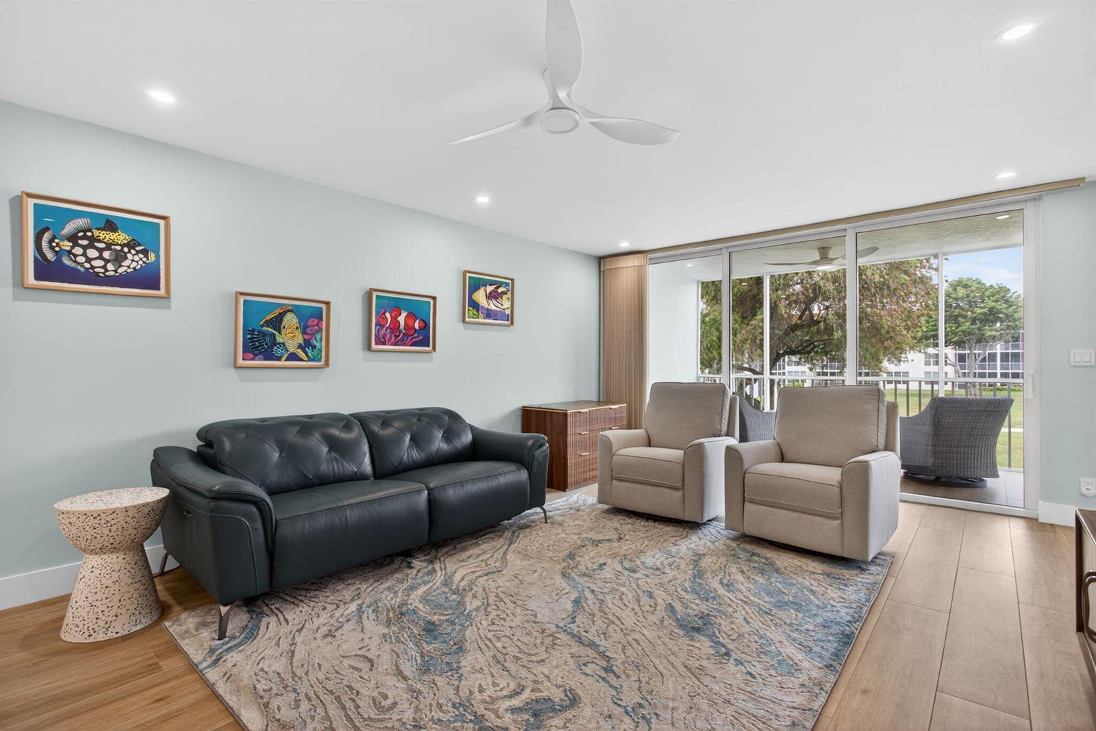 A living room features a dark leather sofa, two beige armchairs, and a patterned rug — 3100 NE 48th Court # 214, Lighthouse Point FL 33064, LIGHTHOUSE POINT, FL