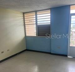 An empty room features light-colored walls, a tiled floor, and windows with horizontal blinds — B 1304 COND. TORRES DE CERVANTES UNIT 1, SAN JUAN, PR