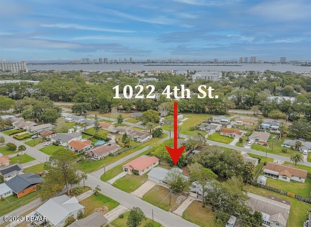 An aerial view shows a residential neighborhood with a red-roofed house marked by an arrow — 1022 4TH STREET, PORT ORANGE, FL