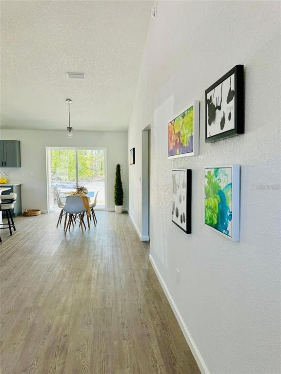 A bright dining area with a glass sliding door is visible beyond a hallway wall — 13731 SW 89TH CIRCLE, OCALA, FL