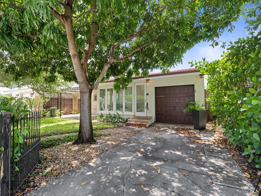 A single-story building with a brown garage door, large windows, and a paved driveway — 1615 N Lakeside Drive, FL 33460, FL