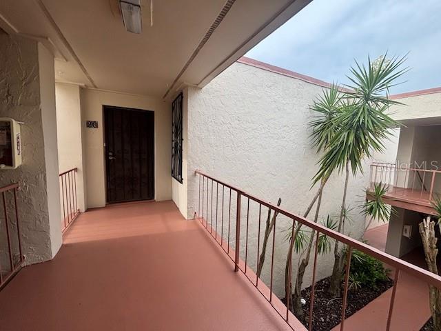 An outdoor walkway with a dark door, metal railings, and a palm tree — 510 ORANGE DRIVE UNIT 20, ALTAMONTE SPRINGS, FL