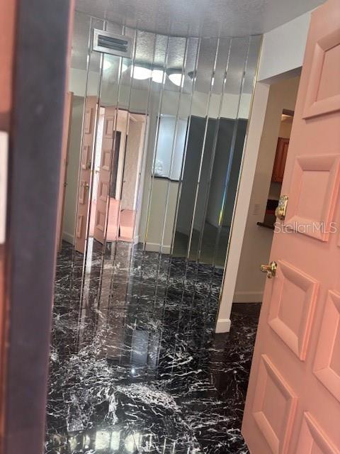 An entryway features a black marble floor and a wall covered in vertical mirror panels — 510 ORANGE DRIVE UNIT 20, ALTAMONTE SPRINGS, FL
