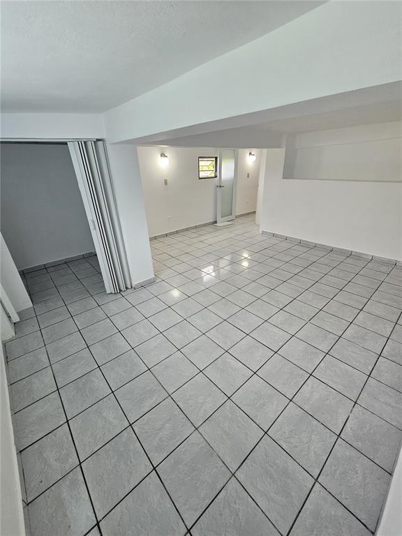 An empty room with white walls, gray tiled floors, and a folding closet door — Calle Cristo Redentor CALLE CRISTO REDENTOR UNIT 57, BO. RABANAL, CIDRA, PR