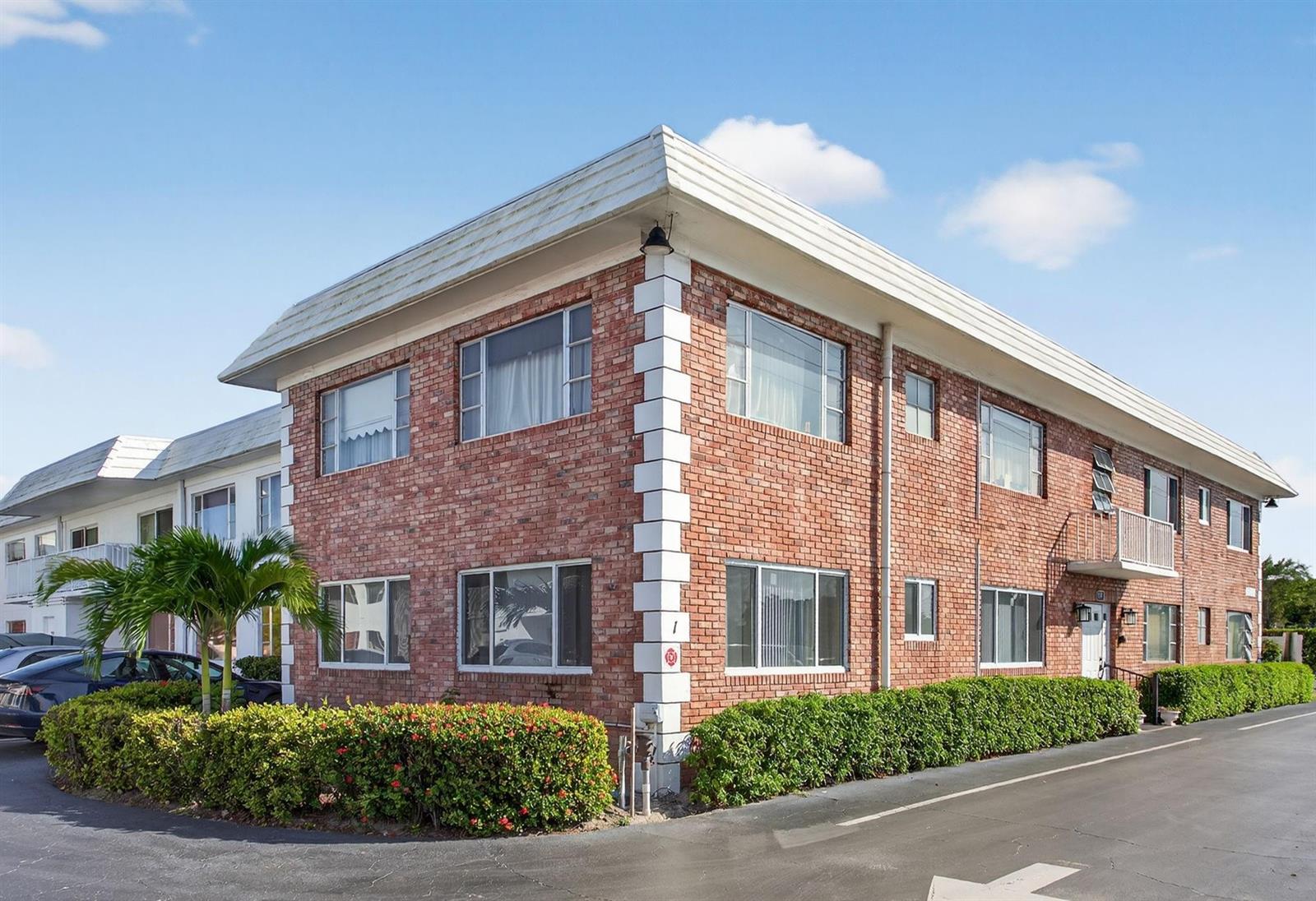 A two-story brick apartment building features white corner accents and a flat roof — 418 S Cypress Road # 110, Pompano Beach FL 33060, POMPANO BEACH, FL