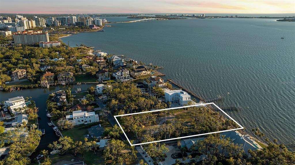 An aerial view shows a vacant waterfront lot outlined in white near a large bay — 2046 ALAMEDA AVENUE, SARASOTA, FL