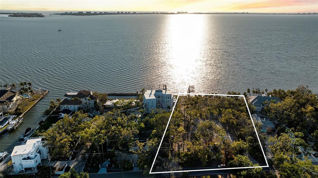 An aerial view shows a vacant waterfront lot outlined in white next to residential homes — 2046 ALAMEDA AVENUE, SARASOTA, FL
