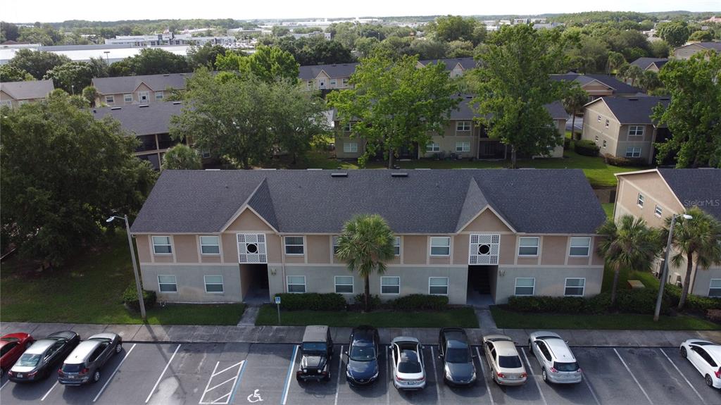 An aerial view shows a two-story apartment building with a parking lot in front — 9909 SWEEPSTAKES LANE UNIT 4, ORLANDO, FL