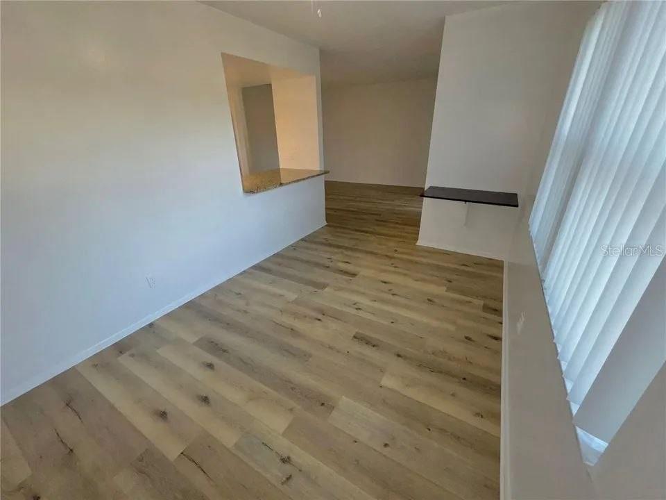 A room with light wood-look flooring, a pass-through window, and a wall-mounted shelf — 9909 SWEEPSTAKES LANE UNIT 4, ORLANDO, FL