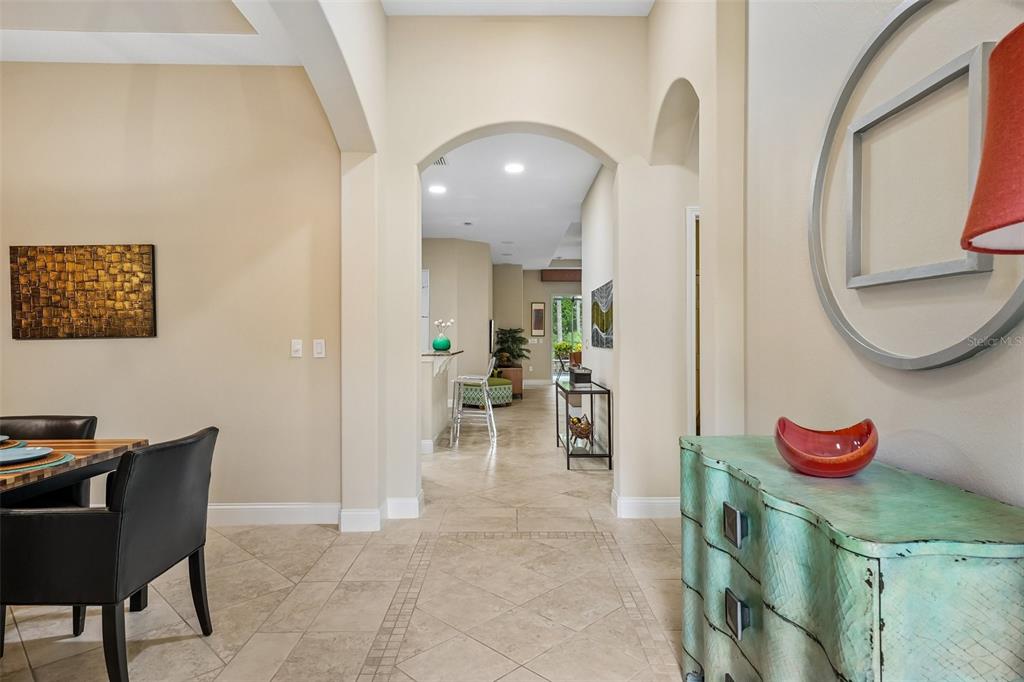 A tiled hallway leads from a dining area toward a kitchen with a breakfast bar — 2919 DEVONOAK BOULEVARD, LAND O LAKES, FL