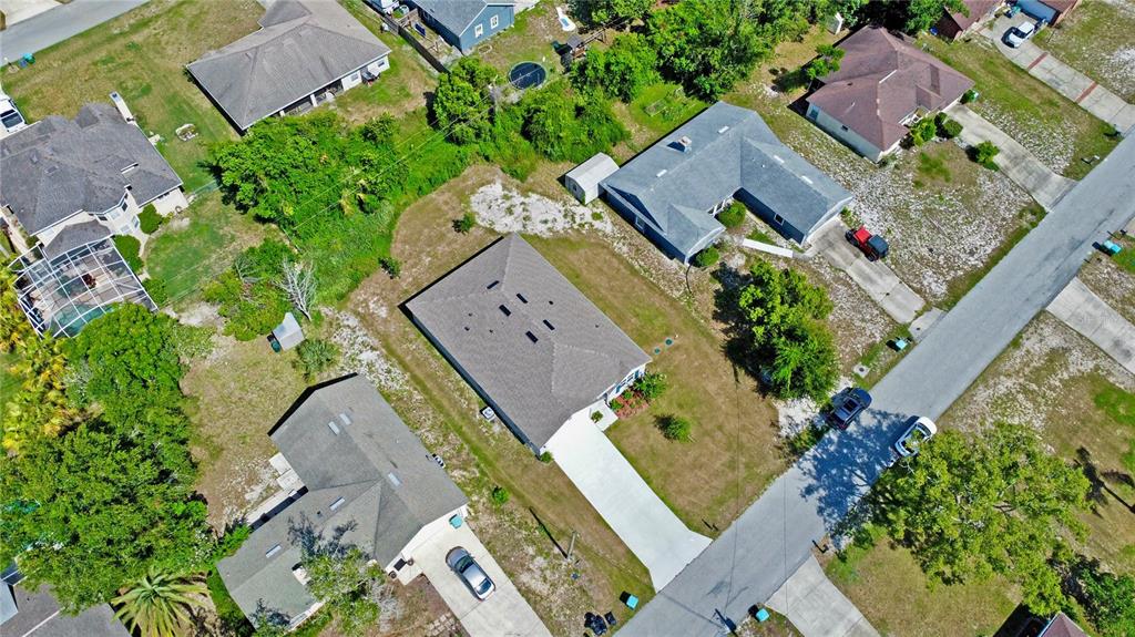 An aerial view shows a suburban neighborhood with several single-family homes and driveways — 2033 E GLORIA DRIVE, DELTONA, FL