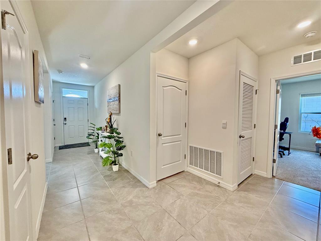 A tiled entryway features a white front door, interior doors, and a view into a room — 2033 E GLORIA DRIVE, DELTONA, FL