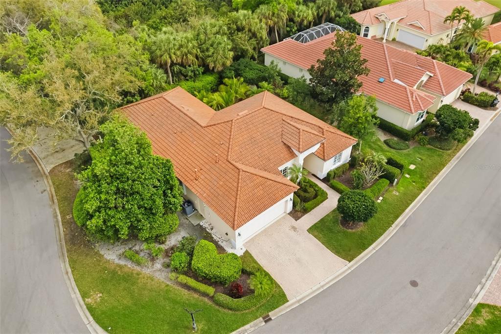 An aerial view of a single-story house with a terracotta tile roof and driveway — 7418 MONTE VERDE, SARASOTA, FL