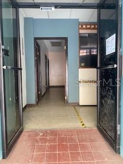 An open doorway leads into a hallway with light-colored tile flooring and blue walls — 26 CORCHADO, AGUADILLA, PR