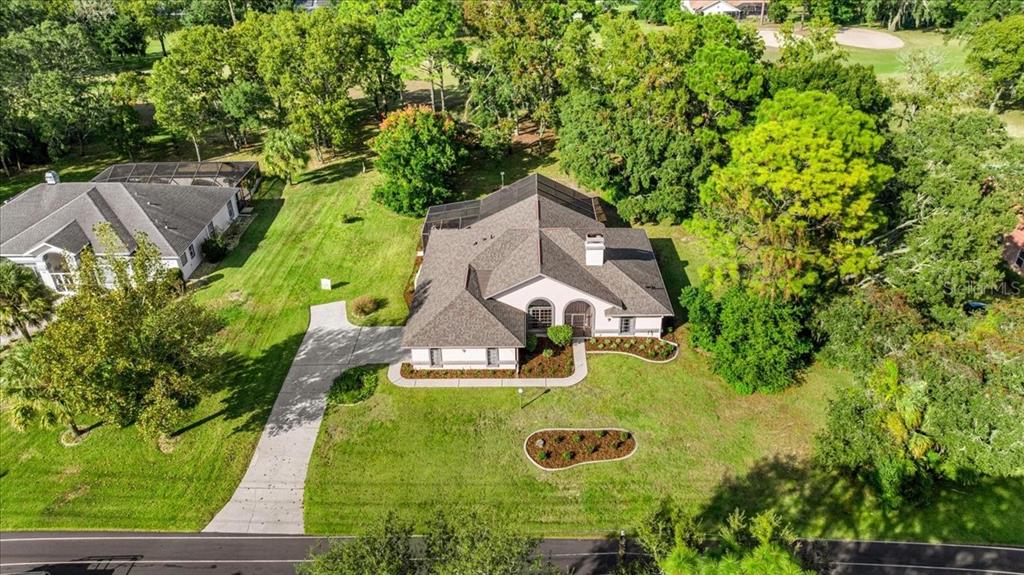 An aerial view shows a single-story house with a shingled roof and a concrete driveway — 631 E LIBERTY STREET, HERNANDO, FL