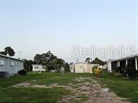 A grassy lot sits between several mobile homes under a clear sky — 5672 HOLIDAY PARK BOULEVARD, NORTH PORT, FL