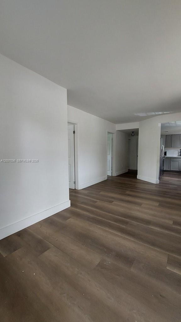 An interior view shows a living area with white walls and wood-look flooring — 6151 SW 35th St # 1, Miramar FL 33023, MIRAMAR, FL