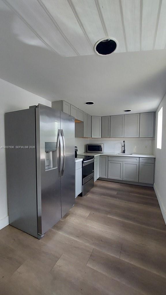 A kitchen features stainless steel appliances, light gray cabinets, and wood-look flooring — 6151 SW 35th St # 1, Miramar FL 33023, MIRAMAR, FL