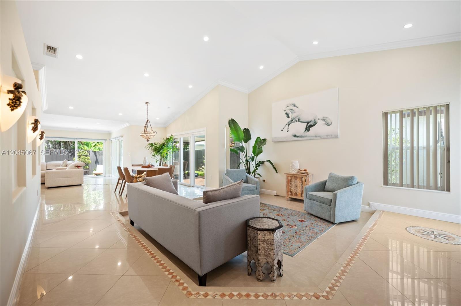A bright, open-concept living and dining area features tile floors, vaulted ceilings, and neutral walls — 982 NW 133rd Ct # 0, Miami FL 33182, MIAMI, FL