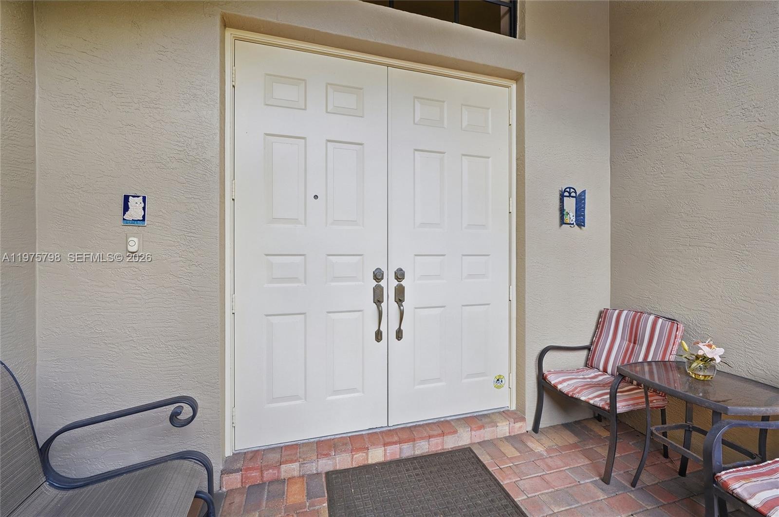 An entryway features double doors, a transom window, tile flooring, and a recessed wall niche — 7771 Via Grande, Boynton Beach FL 33437, BOYNTON BEACH, FL