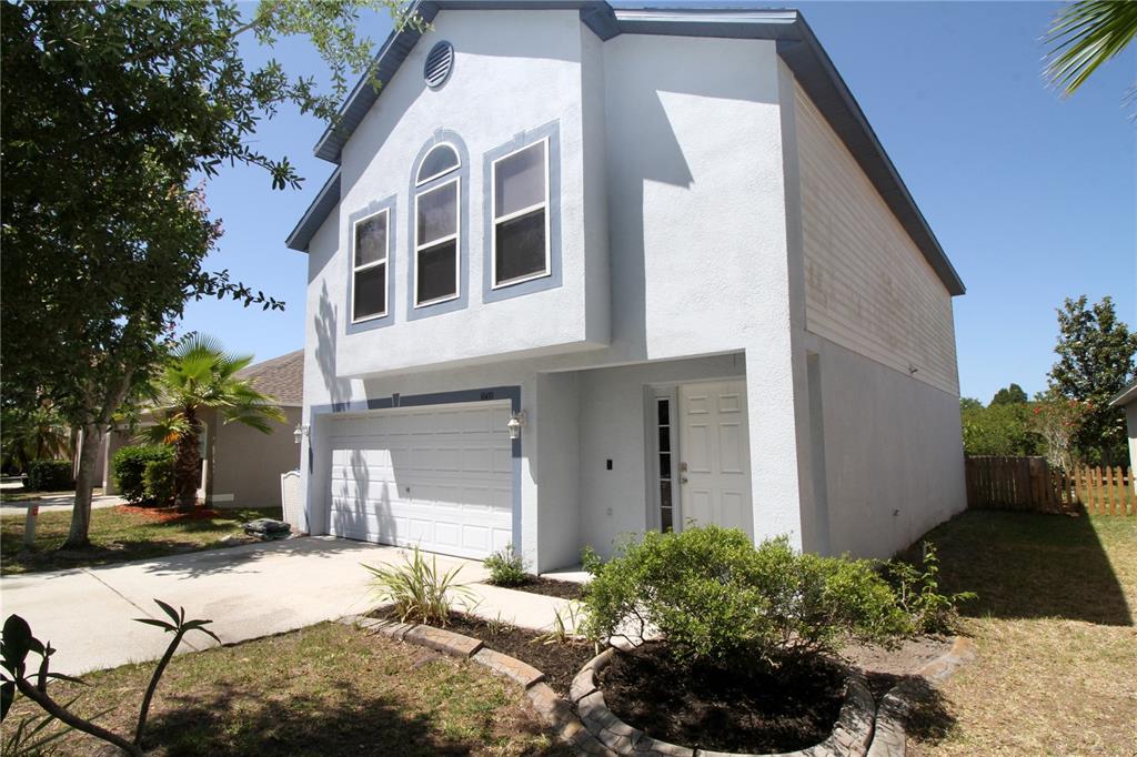 A two-story house with a white garage, front door, and three upper-level windows — 10410 OPUS DRIVE, RIVERVIEW, FL