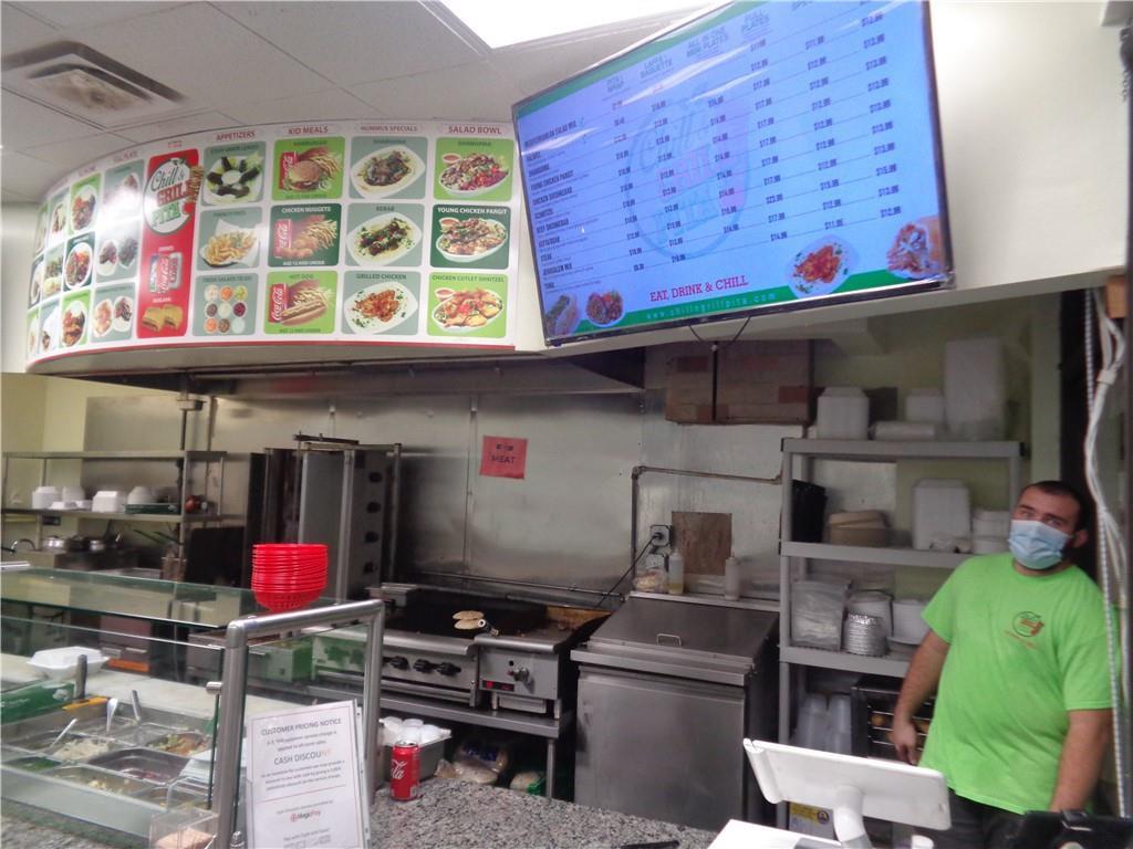 A restaurant interior features a menu board, food preparation equipment, and a masked employee — 7158 N Beracasa Way, Boca Raton FL 33433, BOCA RATON, FL