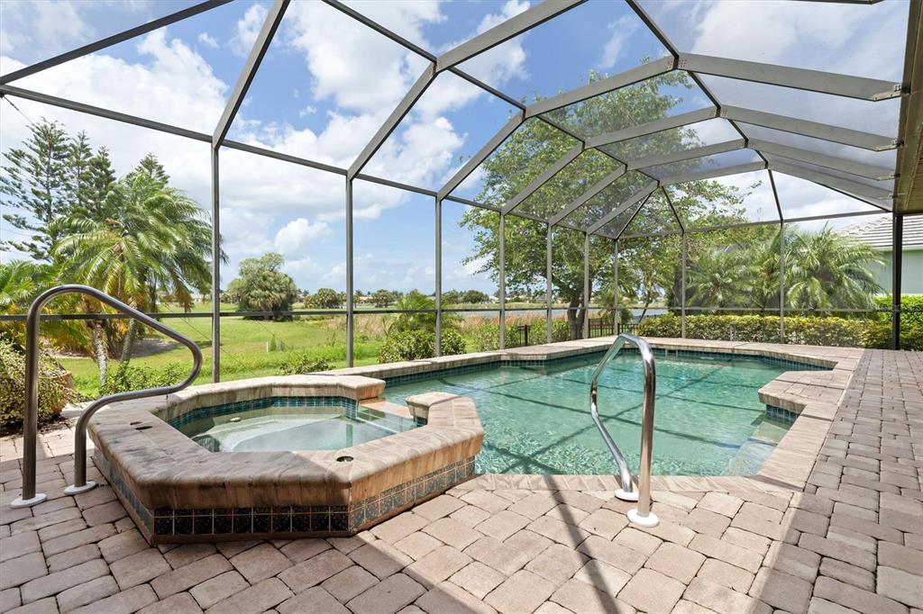A screened-in patio features a swimming pool, a raised hot tub, and paver flooring — 3825 BORDEAUX DRIVE, PUNTA GORDA, FL