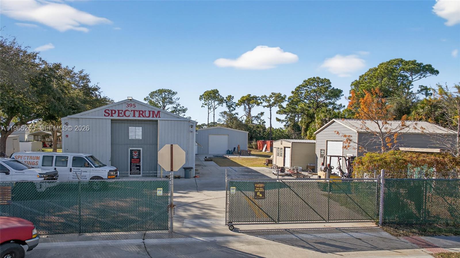 A fenced industrial property features a large metal warehouse building with a white van parked outside — 395 Williams Point Blvd, Cocoa FL 32927, COCOA, FL