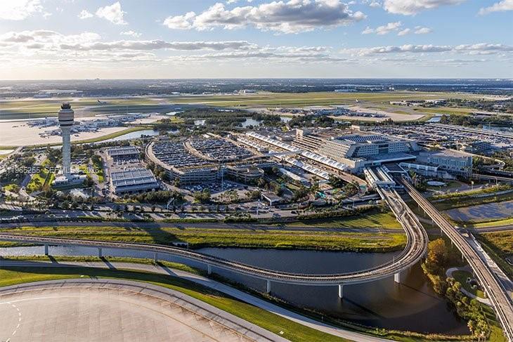 An aerial view of an airport terminal, control tower, parking garages, and surrounding transit tracks — 395 Williams Point Blvd, Cocoa FL 32927, COCOA, FL