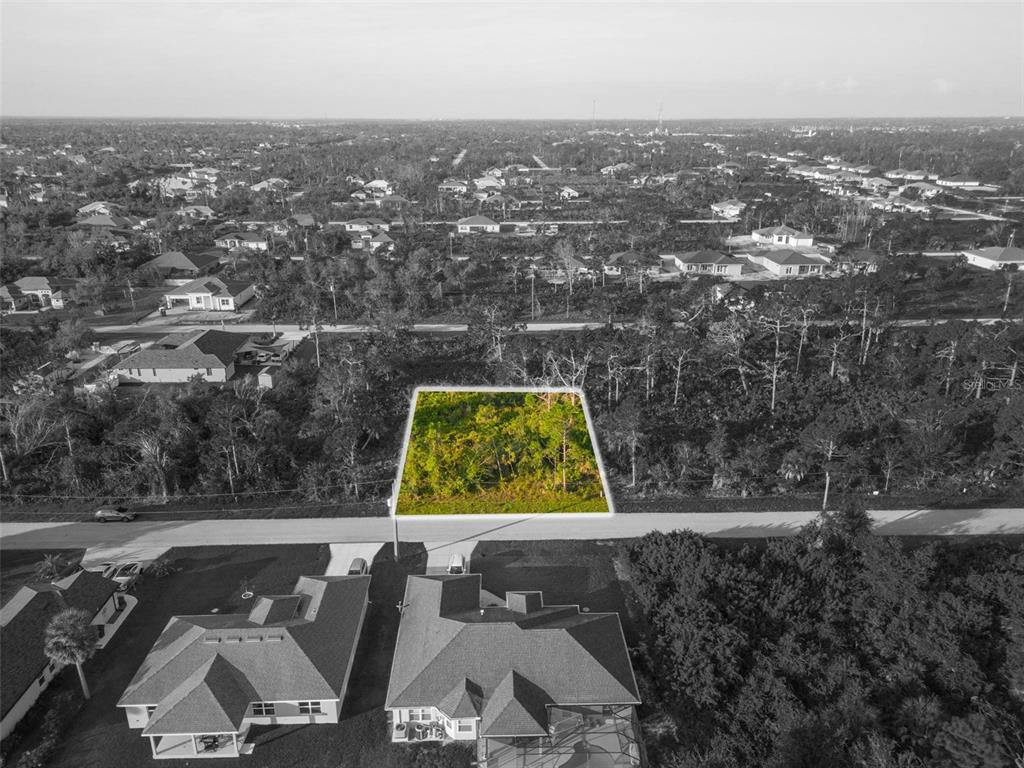 An aerial view shows a rectangular, wooded vacant lot highlighted in green along a road — 13409 YAGER LANE, PORT CHARLOTTE, FL