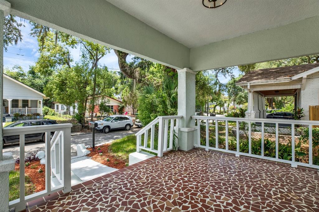 A covered front porch features a mosaic tile floor and white wooden railings — 112 E EMILY STREET, TAMPA, FL