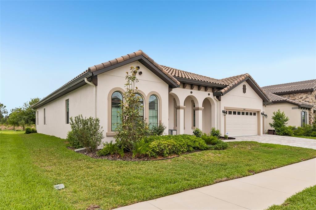 A single-story house with a stucco exterior, arched windows, and a tiled roof — 14537 SWISS BRIDGE DRIVE, LITHIA, FL