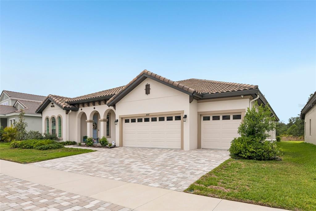 A single-story house with a tiled roof, stucco exterior, and a three-car garage — 14537 SWISS BRIDGE DRIVE, LITHIA, FL