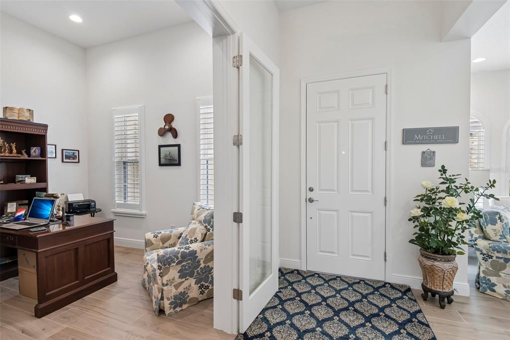 A home office with a wooden desk and chair sits beside an entryway with tile — 14537 SWISS BRIDGE DRIVE, LITHIA, FL