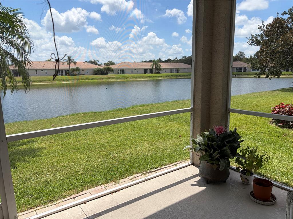 A screened-in patio overlooks a lake with houses in the background — 4019 CASCADE FALLS DRIVE, SARASOTA, FL