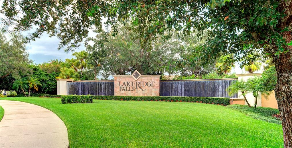 A stone monument sign for Lakeridge Falls features a cascading water wall in a landscaped setting — 4019 CASCADE FALLS DRIVE, SARASOTA, FL