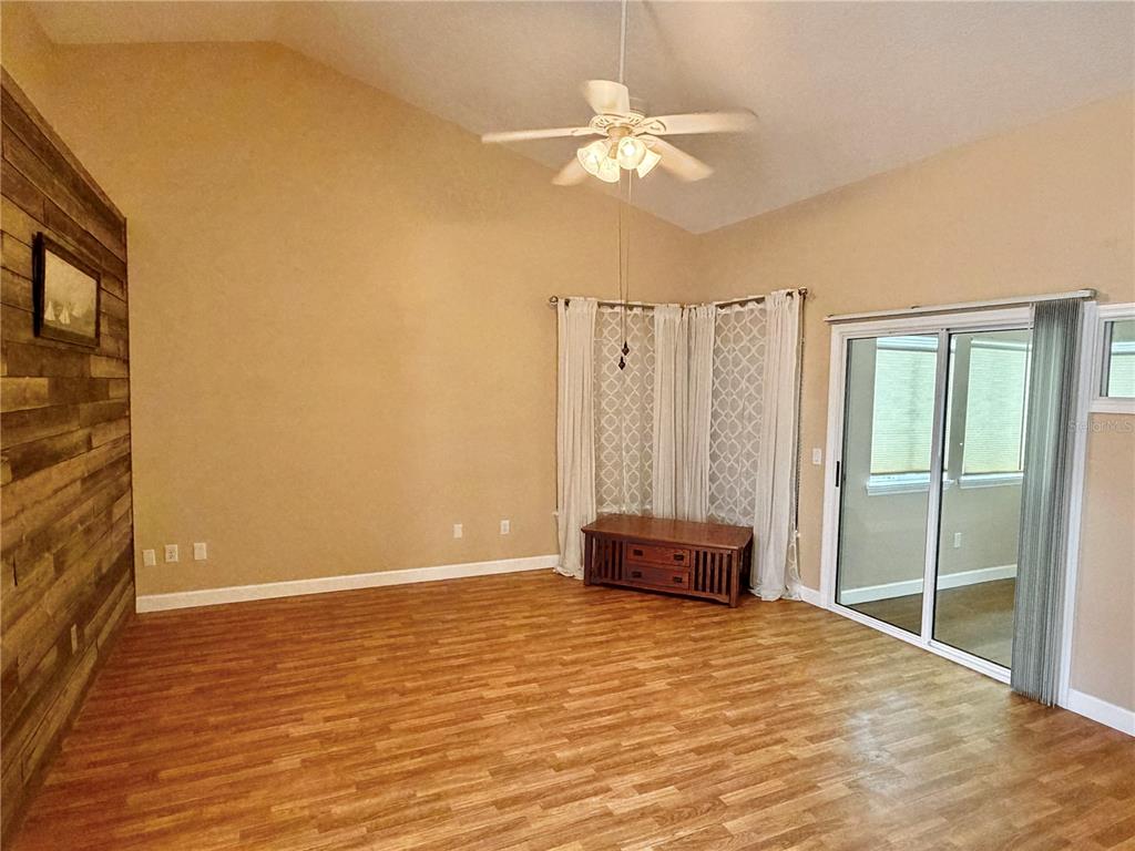 A dining area with a wooden table and chairs adjacent to a kitchen with bar seating — 1122 STILLWATER DRIVE, DELAND, FL