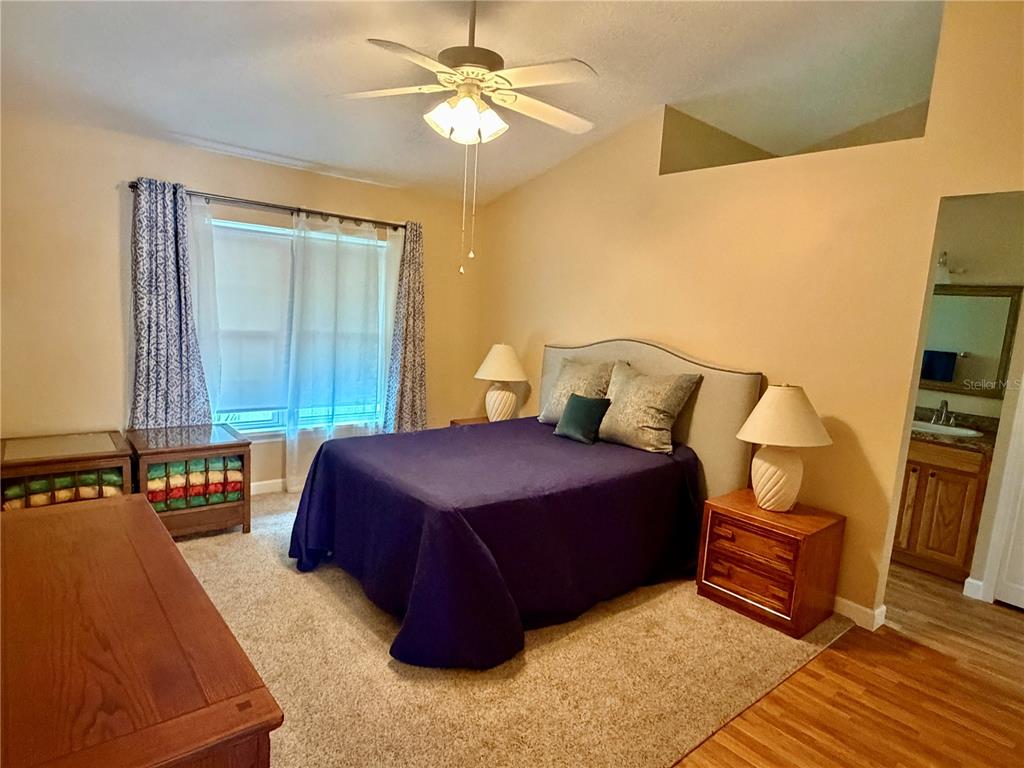 A kitchen with oak cabinets, white appliances, laminate countertops, and light wood-look flooring — 1122 STILLWATER DRIVE, DELAND, FL