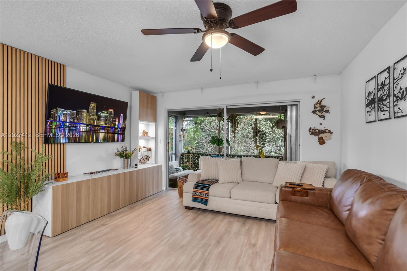 A living room features a wood-slat accent wall, a television, a sofa, and a balcony — 420 NW 70th Ave # 228, Plantation FL 33317, PLANTATION, FL