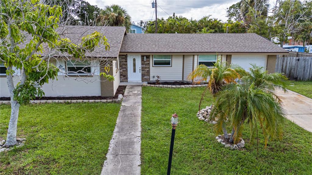 A single-story house with a beige facade, stone entryway, and a concrete walkway — 3831 118TH STREET W, BRADENTON, FL