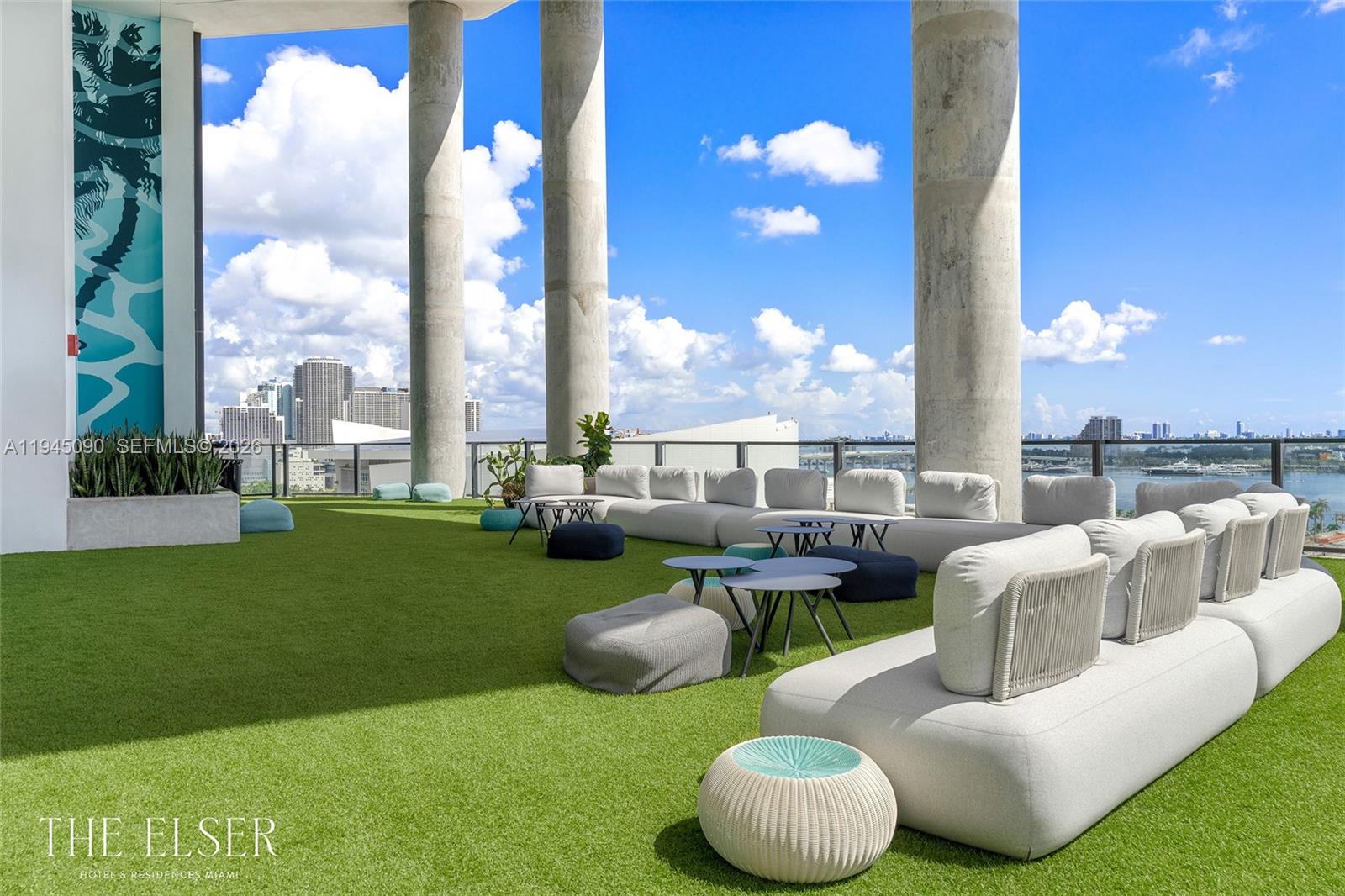 An outdoor rooftop terrace features artificial turf, modular lounge seating, and concrete columns overlooking a city — 398 NE 5th St # 1617, Miami FL 33132, MIAMI, FL