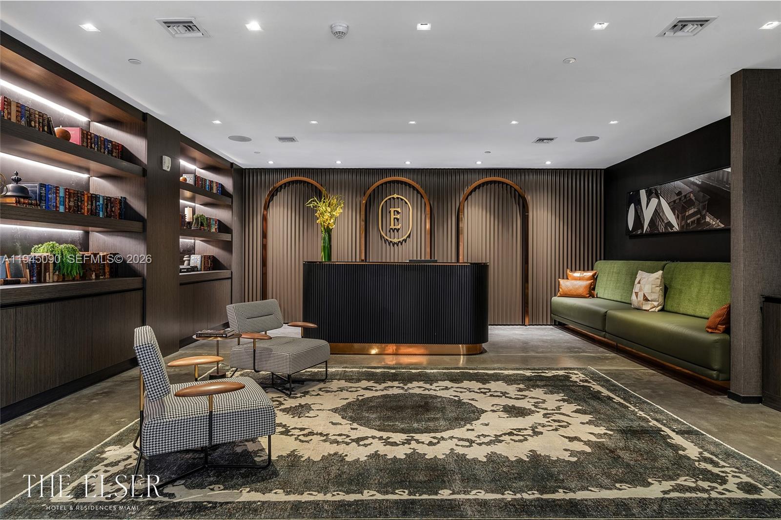 A hotel lobby features a dark reception desk, patterned armchairs, a green sofa, and shelving — 398 NE 5th St # 1617, Miami FL 33132, MIAMI, FL